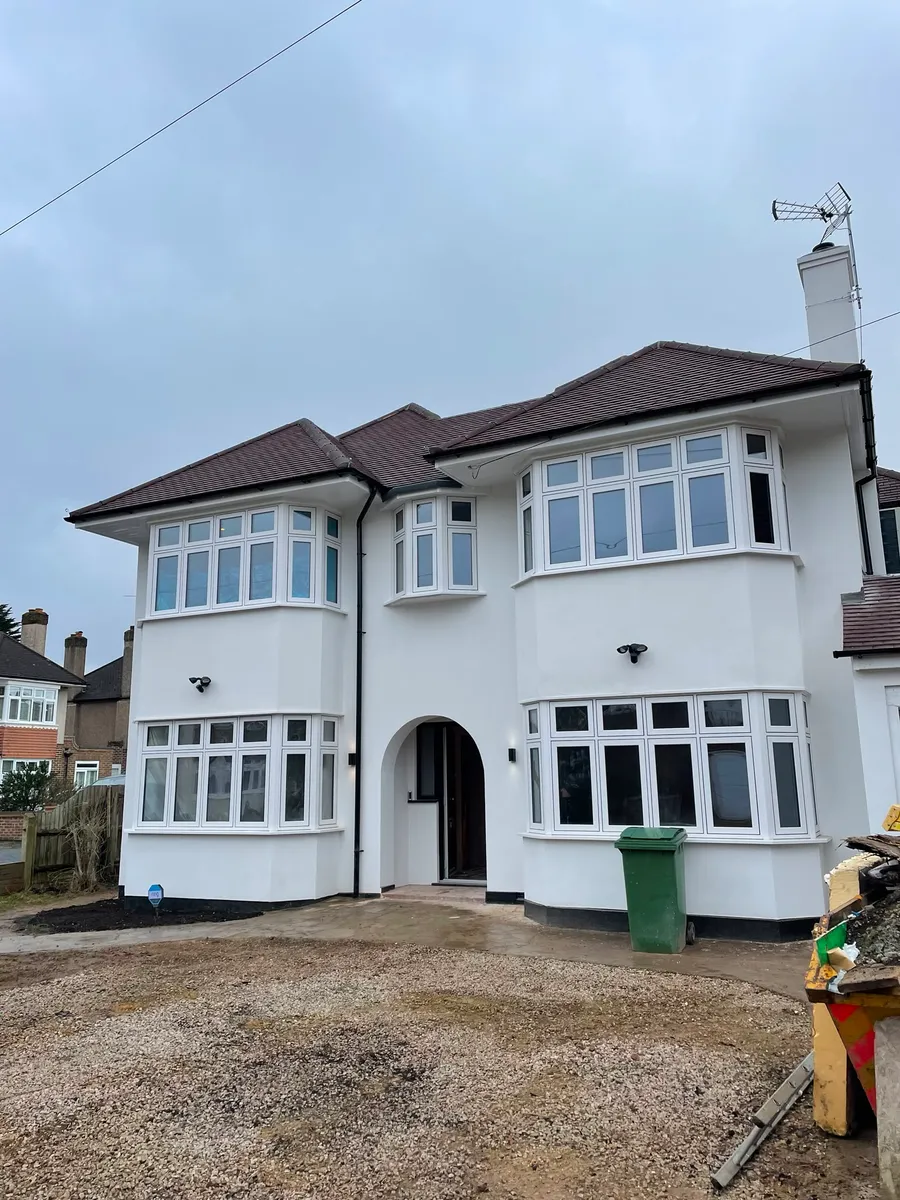 Completed house extension and renovation, rendered in white with replacement bay windows